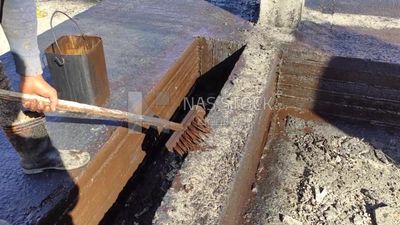 Worker paints the structure with an anti-rust material to protect the concrete from corrosion