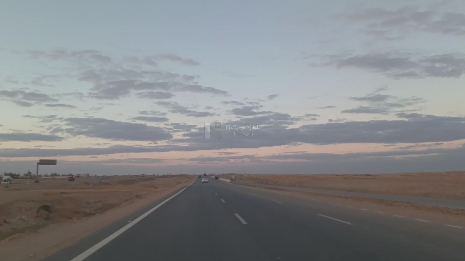 Video from inside a car traveling on the desert road with a stunning sunset view