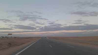 Video from inside a car traveling on the desert road with a stunning sunset view