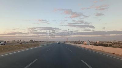 Video from inside a car traveling on the desert road with a stunning sunset view