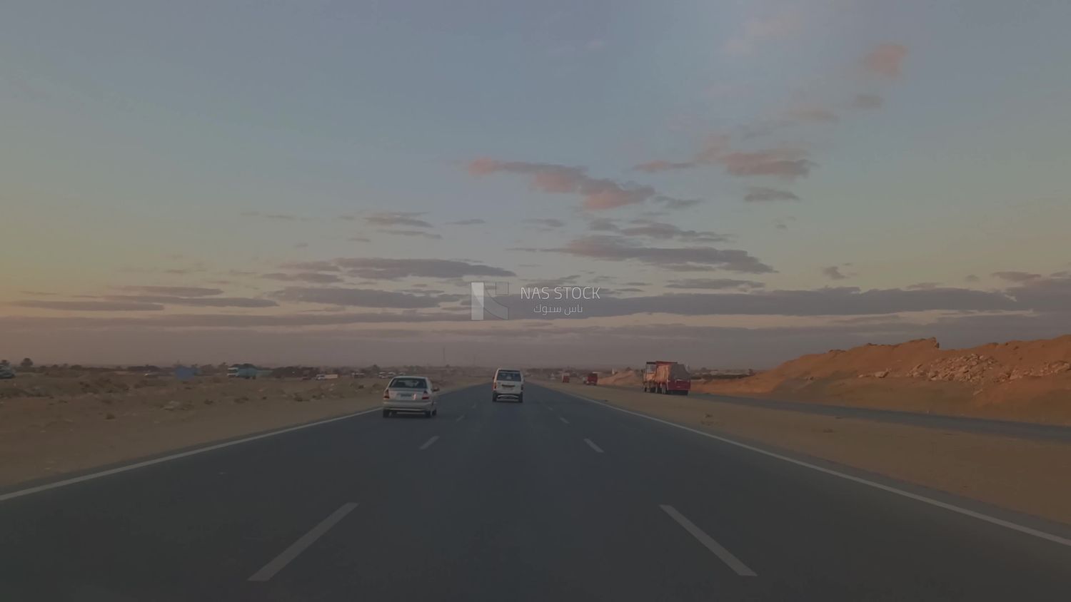 Video from inside a car traveling on the desert road with a stunning sunset view