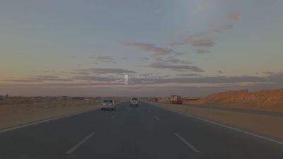 Video from inside a car traveling on the desert road with a stunning sunset view