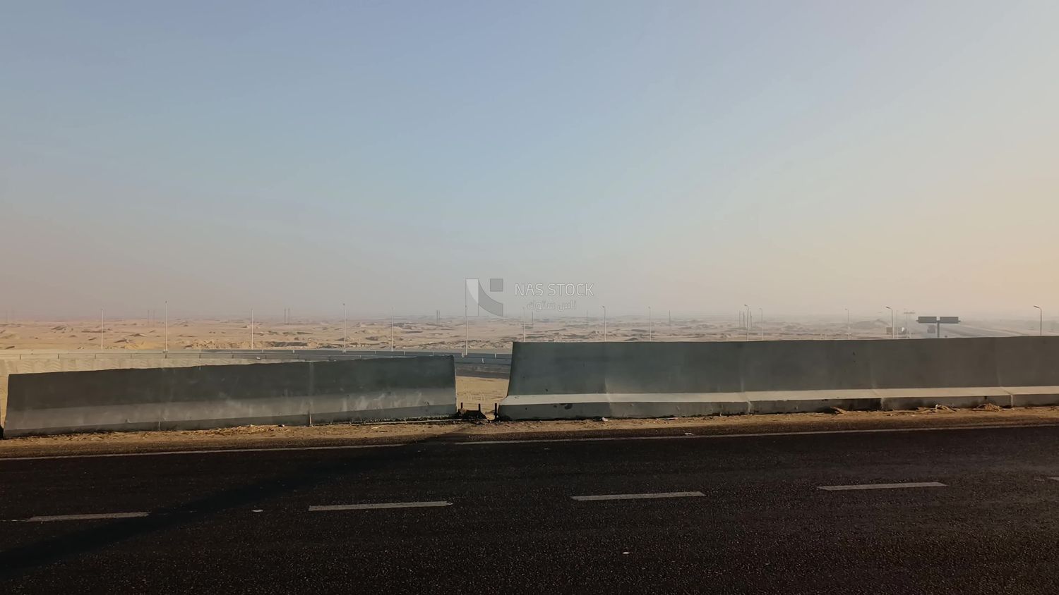 Video of a static scene on the desert road, in which a transport vehicle appears to pass quickly