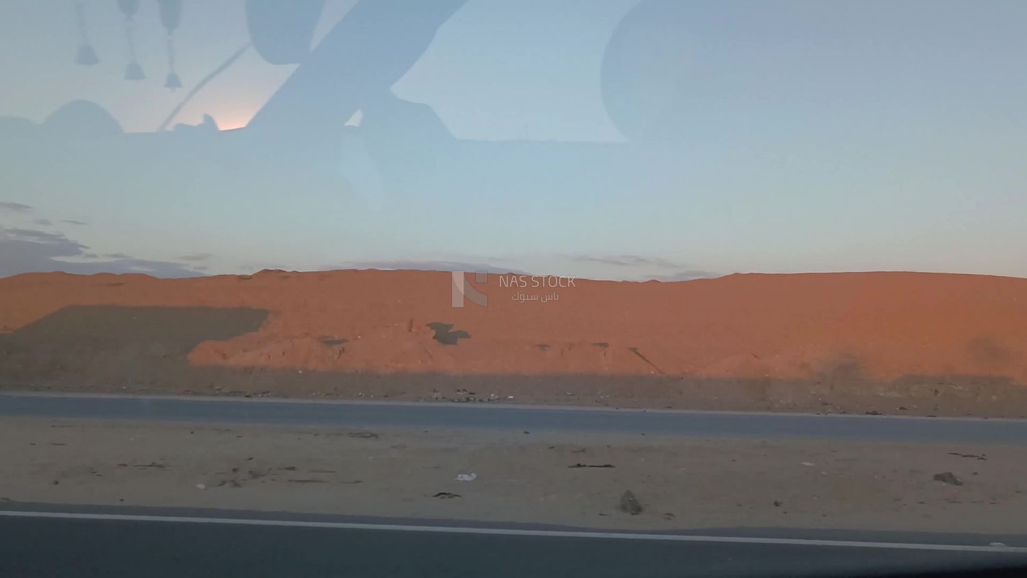 Video from inside a car traveling on the desert road with a stunning sunset view