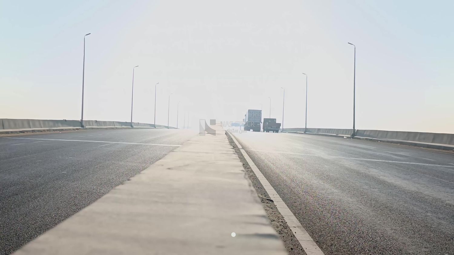 Video showing the sidewalk separating the two directions of the road on the desert road