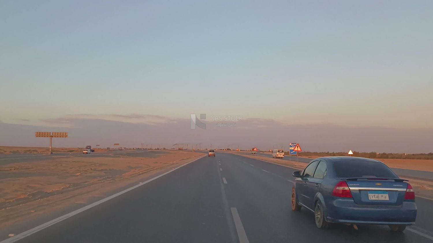 Video from inside a car traveling on the desert road with a stunning sunset view