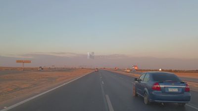 Video from inside a car traveling on the desert road with a stunning sunset view