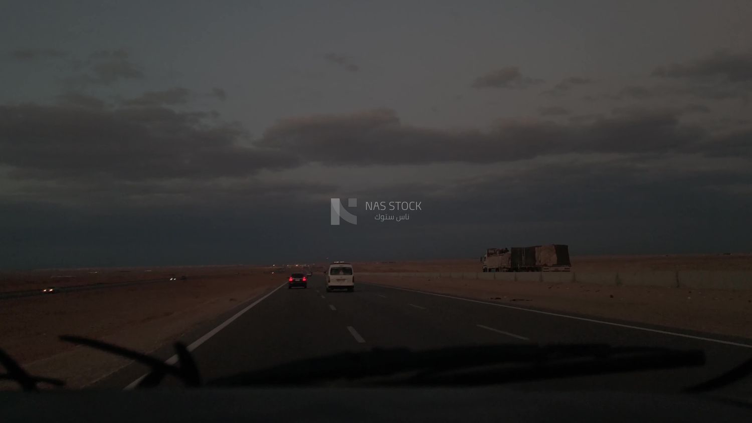 Video from inside a car traveling on the desert road with a stunning sunset view