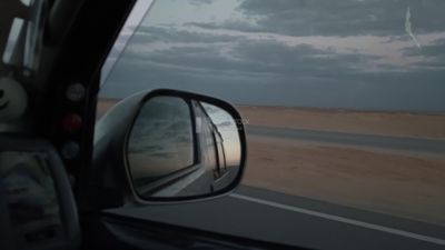 Video of a photographer riding a fast car on a desert road