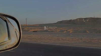 Video of a photographer riding a fast car on a desert road