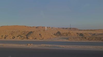 Video showing the golden yellow sands and desert mountains on both sides of the desert road