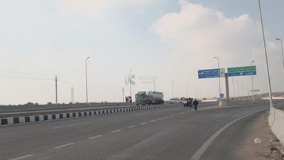 Video showing the desert road with a crossroads and two people walking on the road