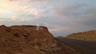 Video showing the golden yellow sands and desert mountains on both sides of the desert road