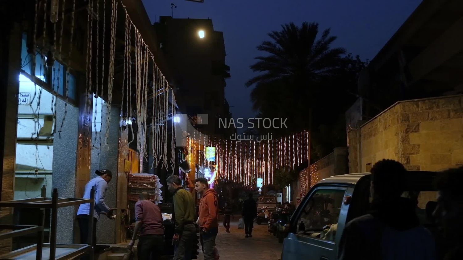 Man selling in a bakery, street, decoration lights