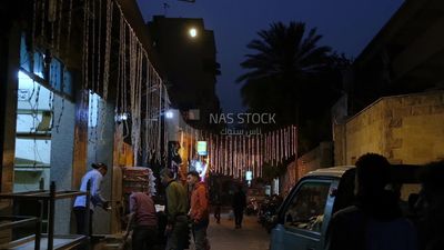 Man selling in a bakery, street, decoration lights