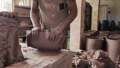 Man prepares pottery dough to be able to shape it