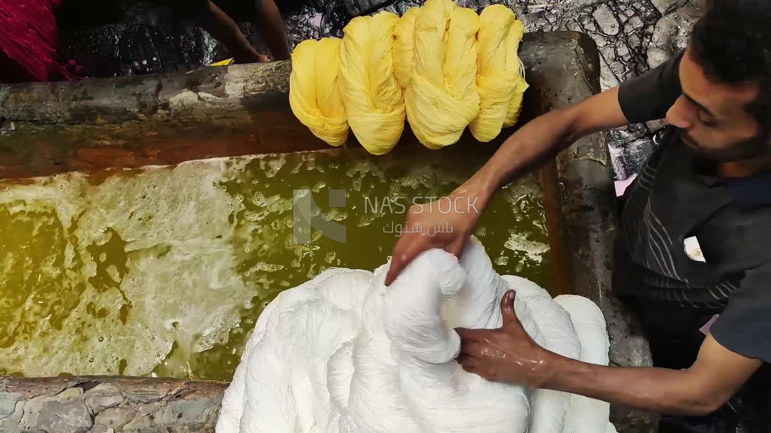 Man works in a yarn dyeing workshop