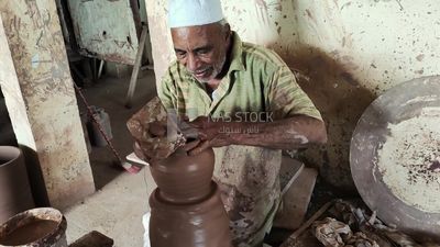 Old man working in a pottery workshop
