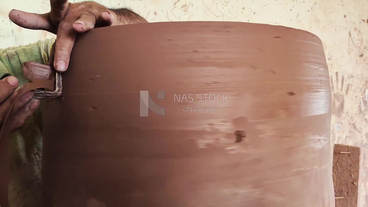 Pottery craftsman forming a pottery vessel