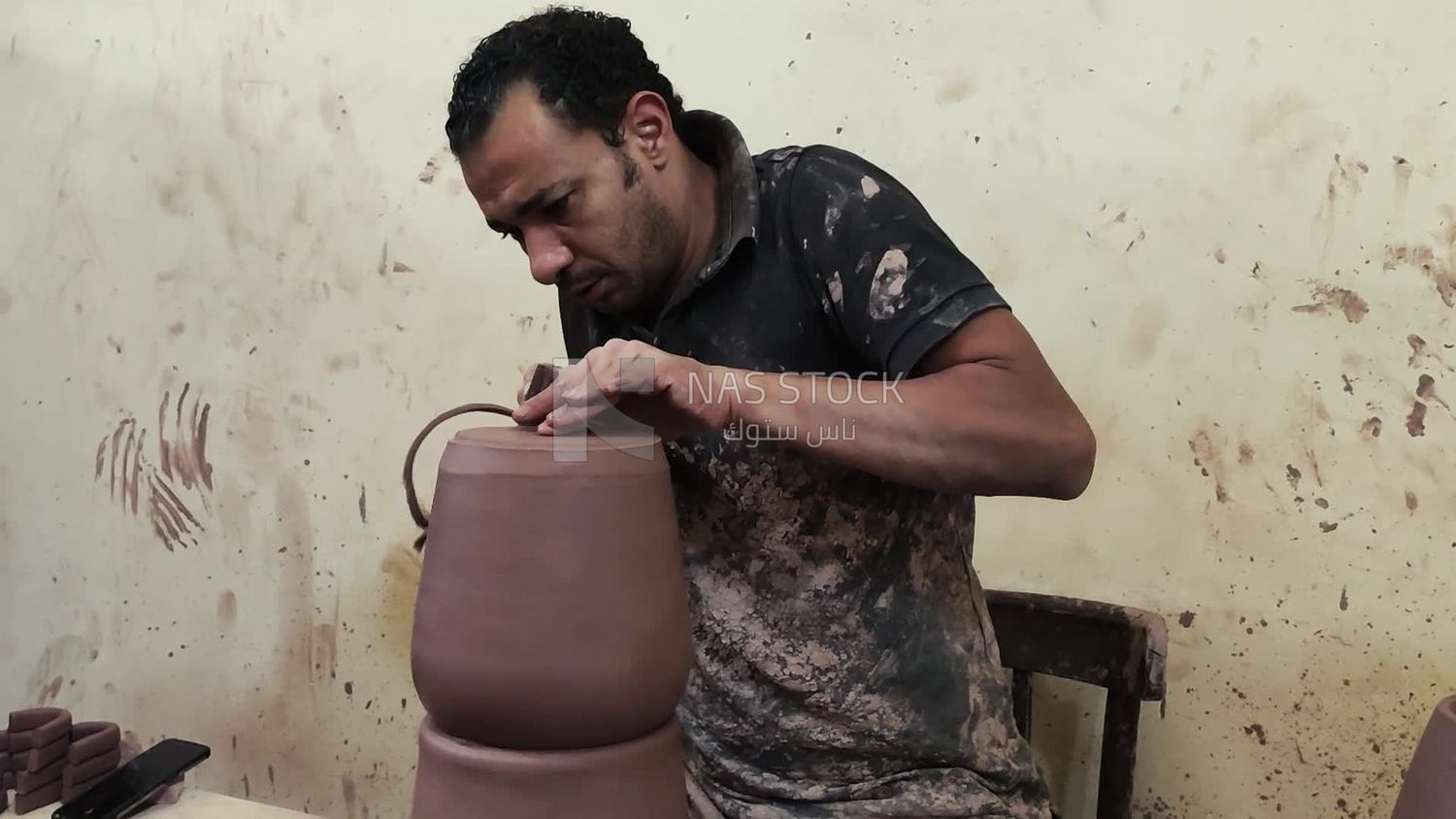 Pottery craftsman forming a pottery vessel