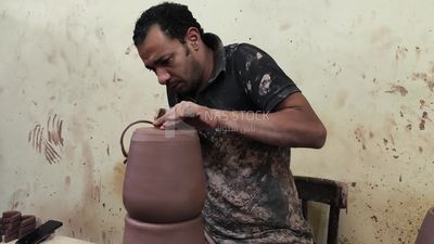 Pottery craftsman forming a pottery vessel