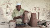 Pottery craftsman forming a pottery vessel