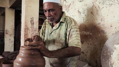 Pottery craftsman forming a pottery vessel