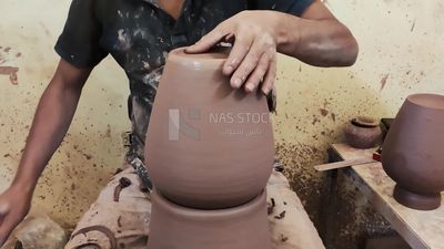 Pottery craftsman forming a pottery vessel