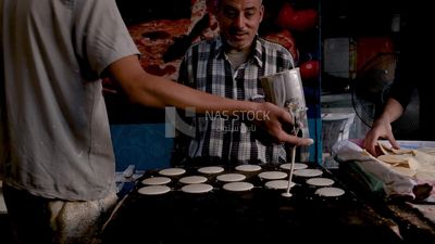 Man standing in qatayef store, Ramadan sweets, Ramadan kareem