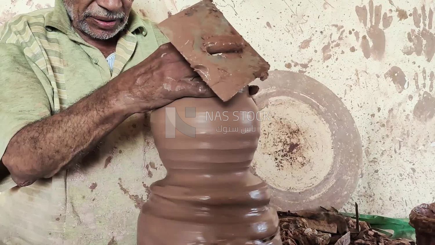 Pottery craftsman forming a pottery vessel
