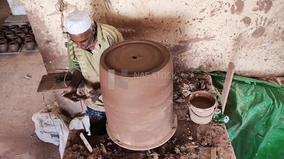 Pottery craftsman forming a pottery vessel