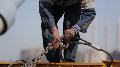 Two workers are trying to put the steel on a steel wire rope, work, construction, engineering tools and equipment
