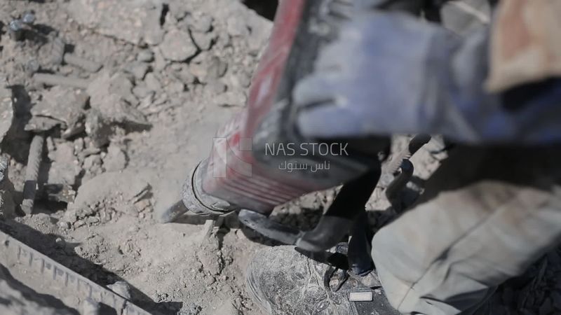 Worker using a drill to make a hole in the ground