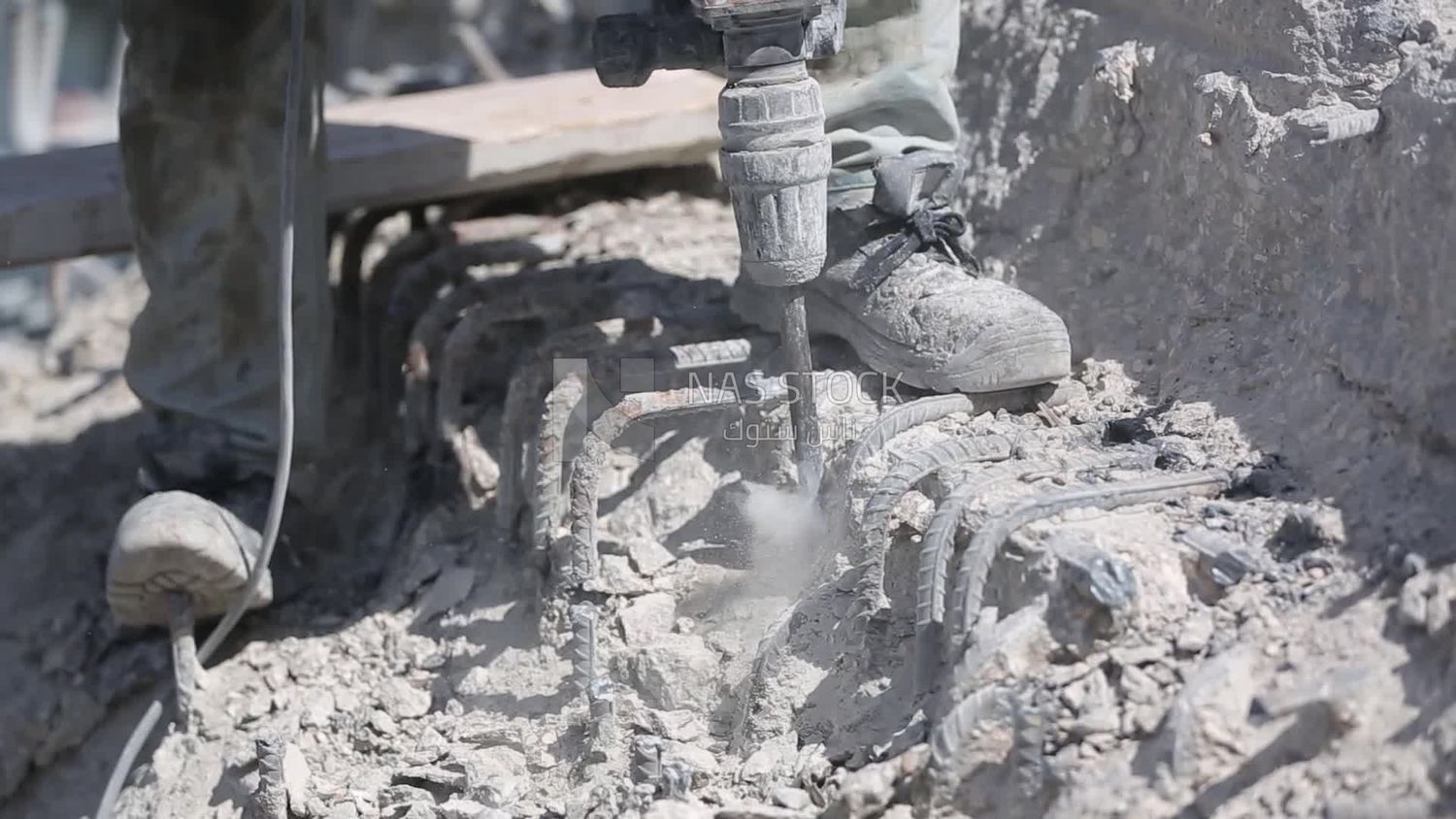 Worker using a drill to make a hole in the ground