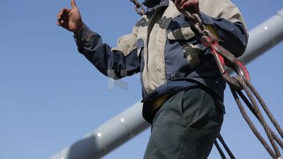 Two workers are trying to put the steel on a steel wire rope, work, construction, engineering tools and equipment