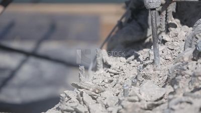 Worker using a drill to make a hole in the ground