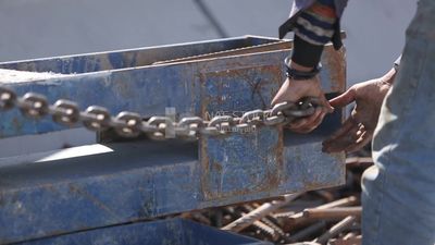 Two workers are trying to put the steel on a steel wire rope, work, construction, engineering tools and equipment