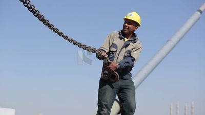 Two workers are trying to put the steel on a steel wire rope, work, construction, engineering tools and equipment
