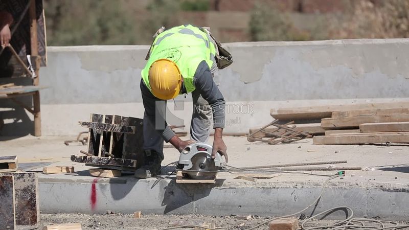 Worker cuts wood on a construction site, works, construction, engineering tools and equipment