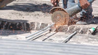 Worker cutting rebar by grinding machine,  engineering tools and equipment