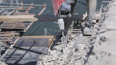 Worker using a drill to make a hole in the ground