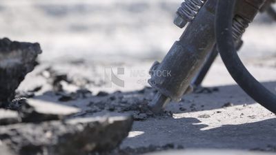 Worker using a drill to make a hole in the ground
