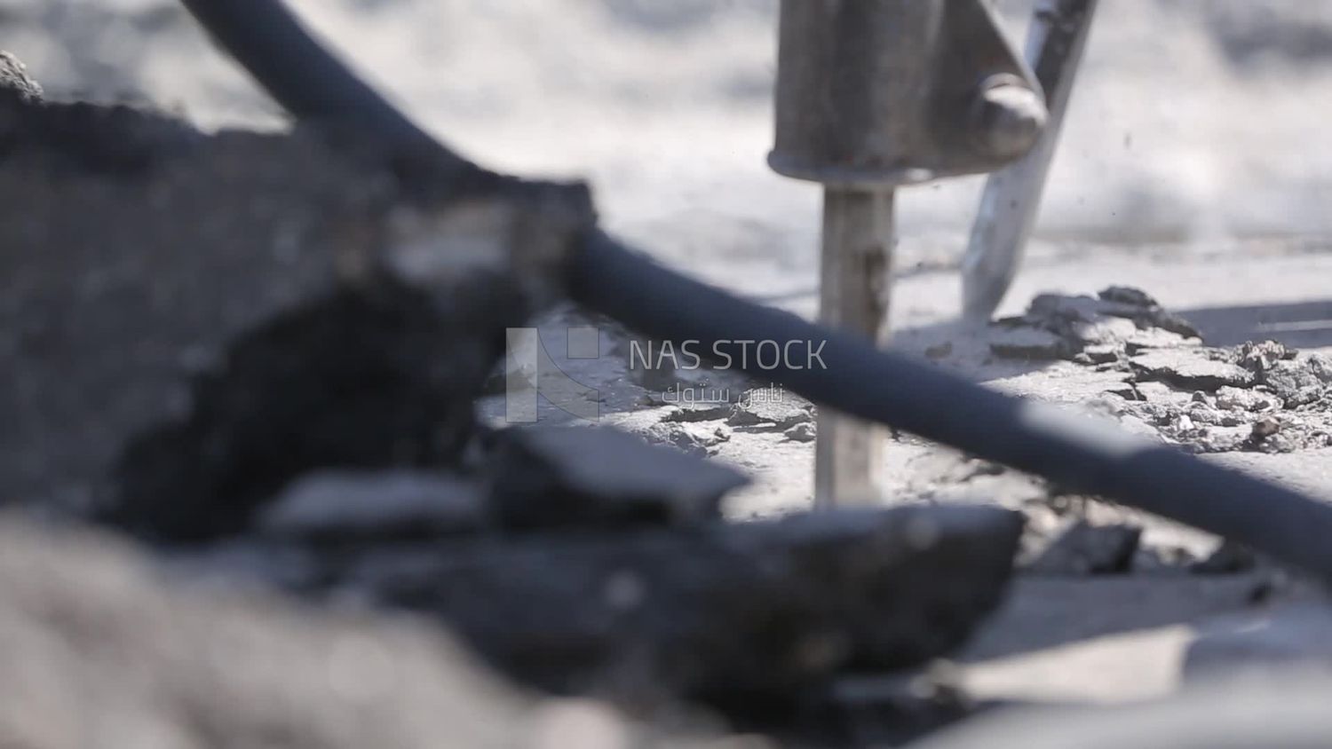 Worker using a drill to make a hole in the ground