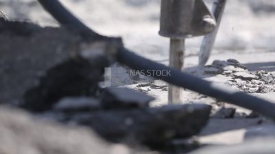 Worker using a drill to make a hole in the ground