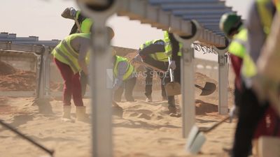 Group of men holding shovels at the site of solar energy