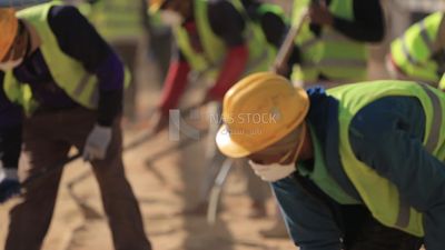 Group of men holding shovels at the site of solar energy