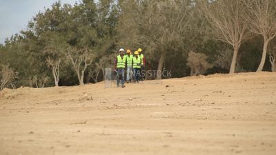 Group of engineers walking in the desert going to work