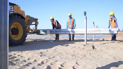 Group of men working on a site of solar energy