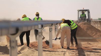 Group of men holding shovels at the site of solar energy