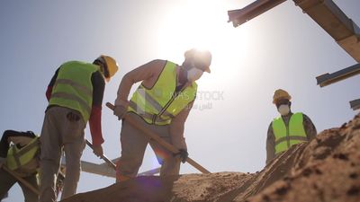 Group of men holding shovels at the site of solar energy